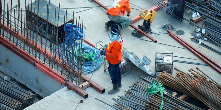 Steel workers installing steel bars on a building site.