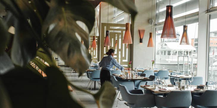 A steward making sure restaurant is clean and tidy.