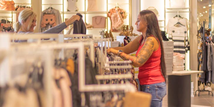 Stock clerk placing retail items up for display.