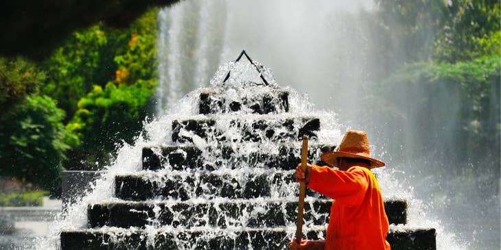 Street sweeper operator cleaning the surroundings of the fountain of a park