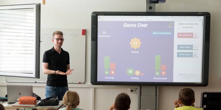 Un maestro da una lección interactiva a sus alumnos en un proyector.