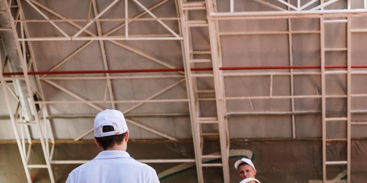 tennis coach holding a racket and talking to a student