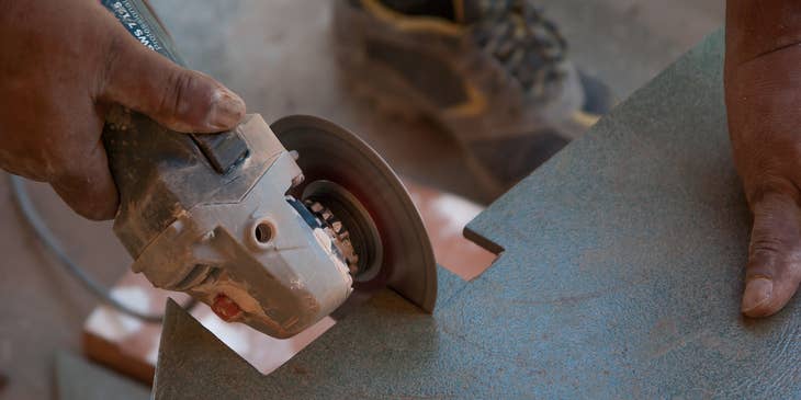 Tile setter cutting down a tile