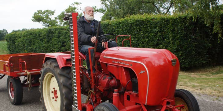 Tractor Driver maneuvering towards the plantation to pick up the harvested crops