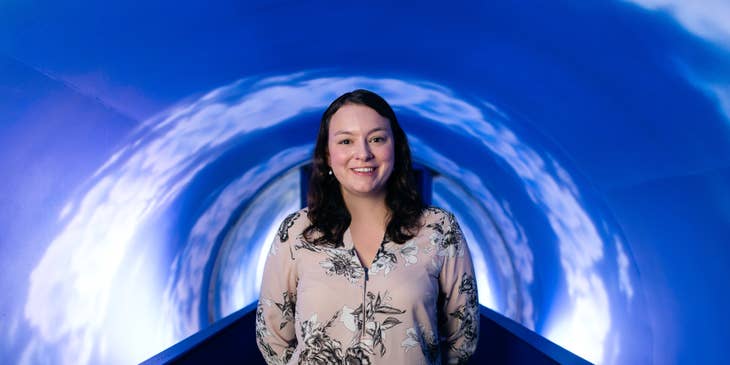 female tunnel engineer posing on the camera with her newly-built tunnel system project behind