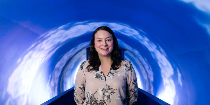 female Tunnel Engineer posing on the camera with her newly-built tunnel system project behind