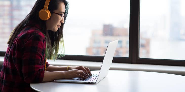 Typist transcribing an audio recording in the laptop