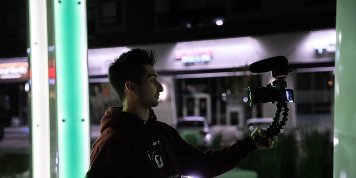 a vlogger using his camera with tripod vlogging during nighttime