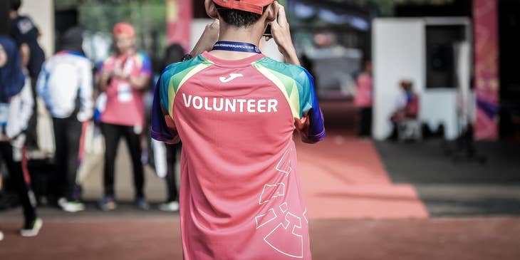 young volunteer taking photos of the event and his teammates while standing