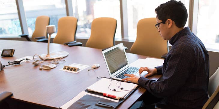 a web analyst working alone after a meeting inside the conference room