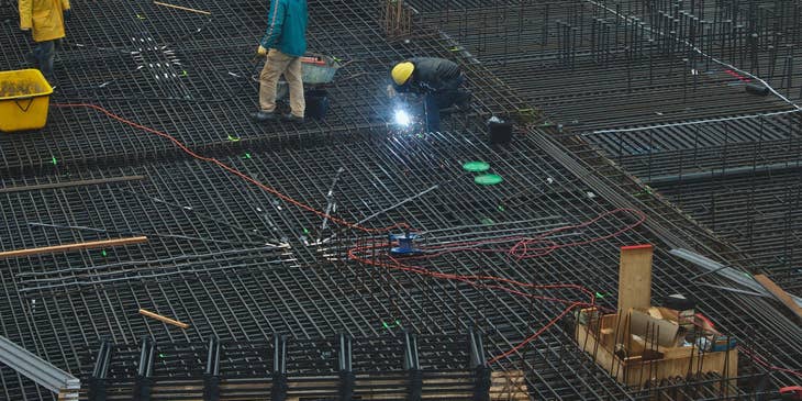 Welding inspector assessing welding work being done on a construction site