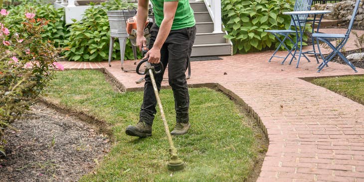 yard worker mowing grass on a residential property