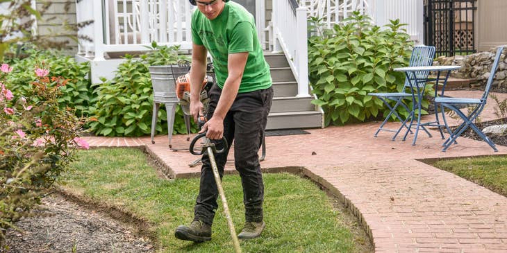 yard worker mowing grass on a residential property