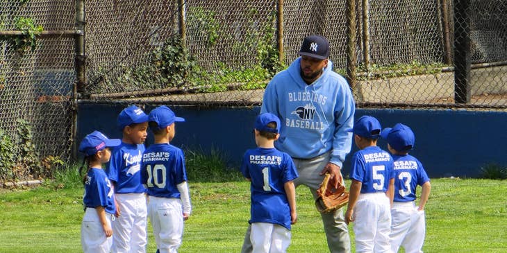 A man coaching a little league team.