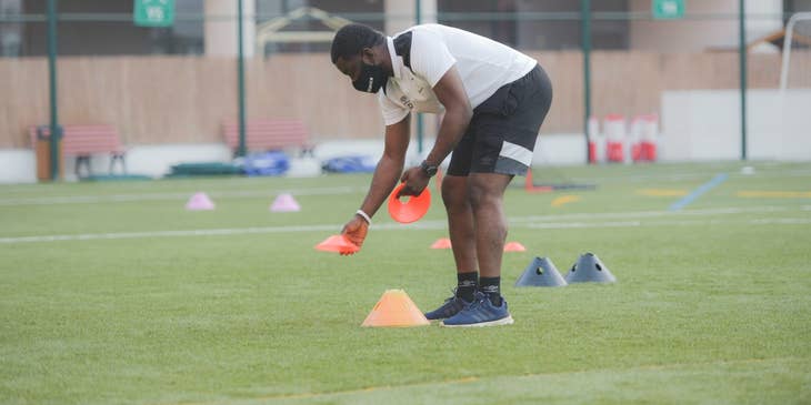 Youth sports instructor getting ready for the day's practice on a football field